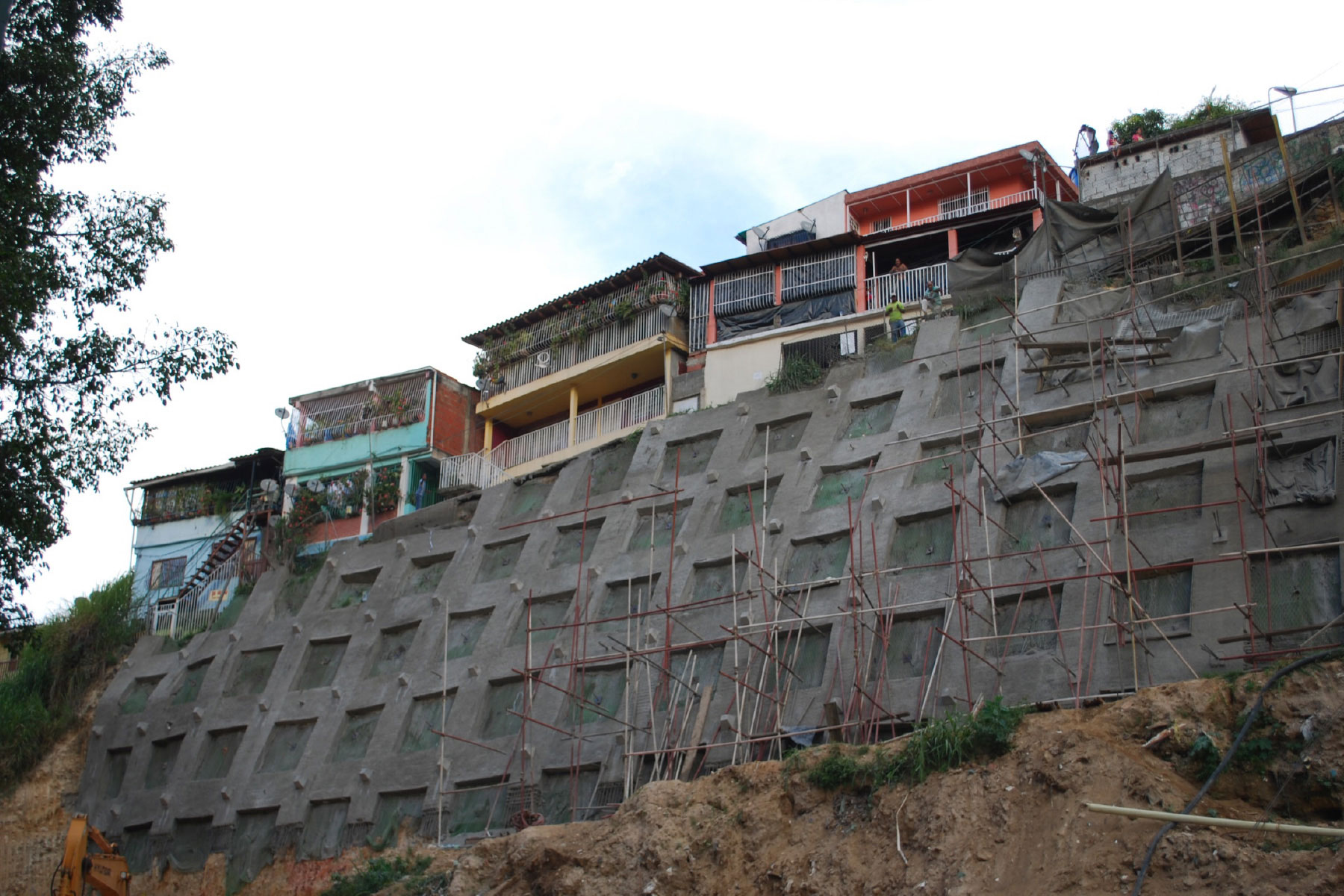 ￼Pantalla atirantada reticulada de 16 m de altura, reforzada con geomallas metálicas y geomantas verdes ECOGREEN para el control de erosión y estabilización de talud ubicado en el Barrio Santa Cruz, Municipio Baruta. 2011