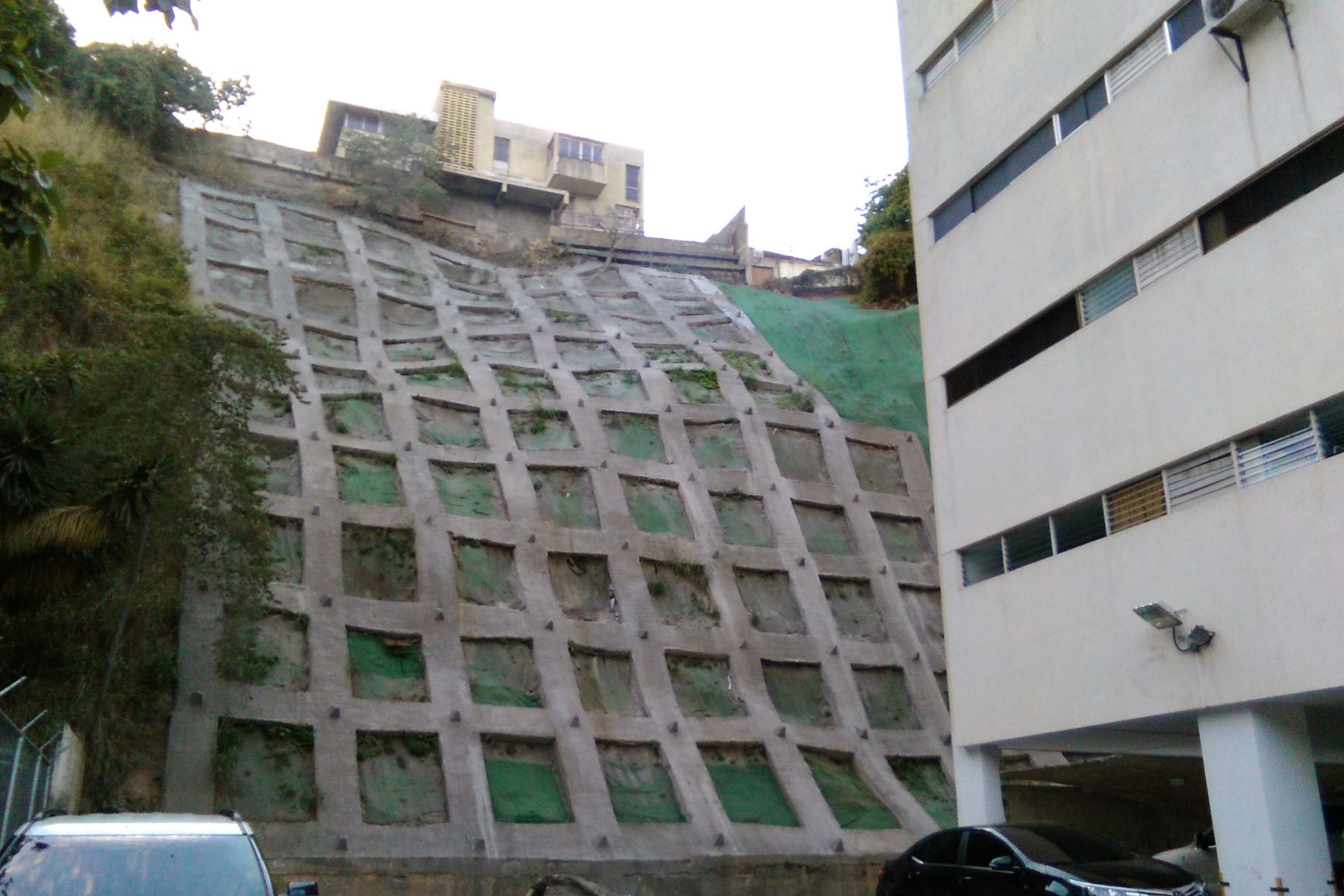 Pantalla atirantada reticulada de 20 m de altura, reforzada con geomallas metálicas y geomantas verdes ECOGREEN. Residencias Icabaru. Municipio Baruta. 2014 Pantalla atirantada reticulada de 20 m de altura, reforzada con geomallas metálicas y geomantas verdes ECOGREEN. Residencias Icabaru. Municipio Baruta. 2014